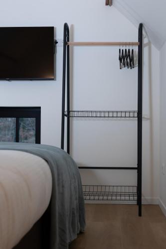 a bedroom with a bed and a tv on a wall at Bed & Breakfast De Pol in Doetinchem