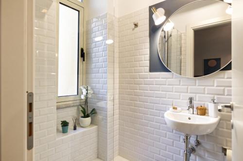 a white bathroom with a sink and a mirror at Savi Guest House metro B S Paolo in Rome
