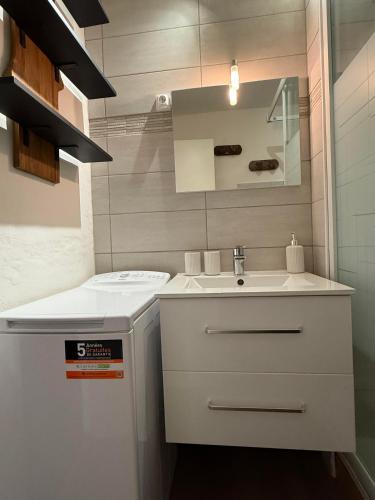 une salle de bain blanche avec un lavabo et un miroir dans l'établissement Superbe appartement 5 à 6 couchages front de neige Risoul, à Risoul