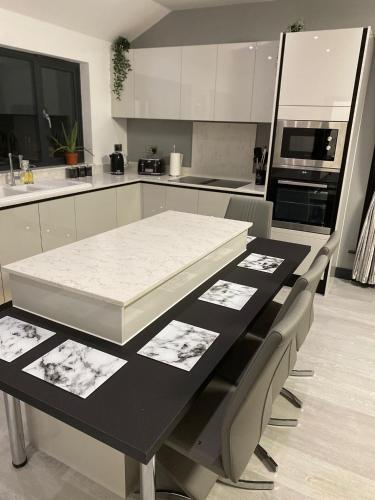 a kitchen with a black and white table and chairs at Belvedare-Suffolk in Sudbury