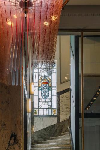 a stained glass window in a building with a staircase at Reichshof Hotel Hamburg in Hamburg