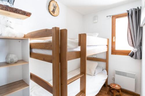 a room with two bunk beds and a window at Appartement pour 6, 700m des pistes de ski in La Joue du Loup