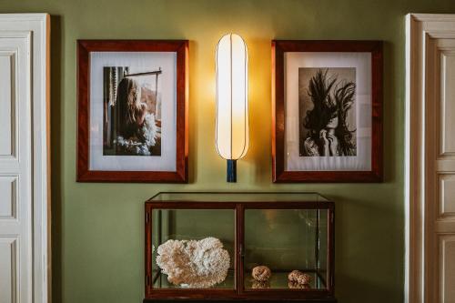 a wall with pictures and a light in a room at Palazzo Flora in Gallipoli