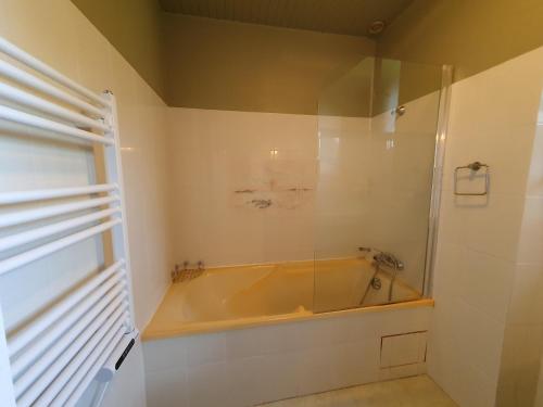 une baignoire dans une salle de bain avec une fenêtre dans l'établissement Jolie maison vue mer 6 personnes à Plouguerneau, à Plouguerneau