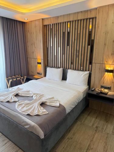 a bedroom with a large bed with white sheets at world say hotel in Bostaniçi