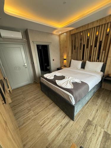 a bedroom with a large bed and wooden floors at world say hotel in Bostaniçi