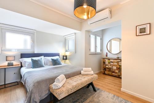 a bedroom with a large bed and a bench at Casa do Chafariz Family Ap by Sé Apartamentos in Braga