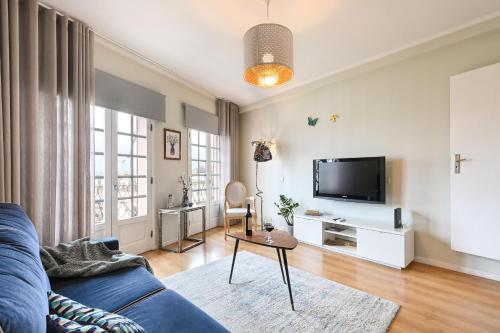 a living room with a blue couch and a tv at Casa do Chafariz Family Ap by Sé Apartamentos in Braga