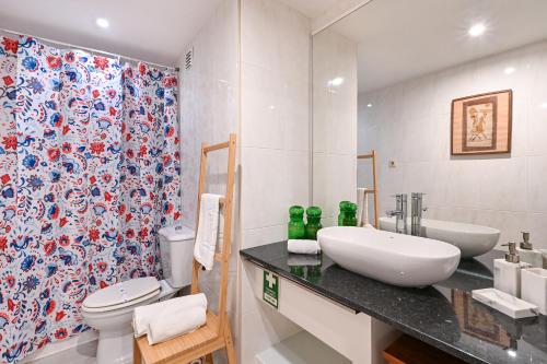 a bathroom with a sink and a toilet and a shower at Casa do Chafariz Family Ap by Sé Apartamentos in Braga