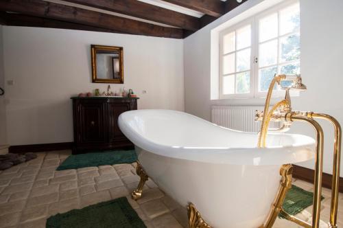 La salle de bains est pourvue d'une baignoire blanche et d'une fenêtre. dans l'établissement Luxury gite in Château Hostens-Picant vineyard, à Les Lèves-et-Thoumeyragues