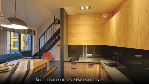 a kitchen with wooden cabinets and a staircase at Norweska Dolina Family&Pet-friendly Resort in Szklarska Poręba