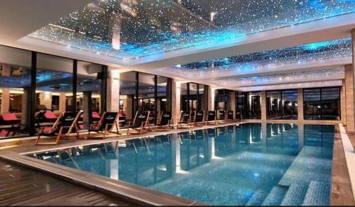 una grande piscina con sedie in un edificio di Apartman B64 Residence Hill Kopaonik a Kopaonik