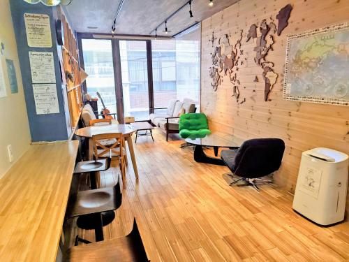 a room with desks and chairs and a wall with a map at HOSTEL PAQ tokushima in Tokushima