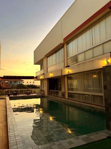 a building with a swimming pool in front of it at Salt Beach Atalaia Residence Inn in Salinópolis