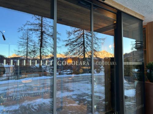 a reflection of a mountain in the windows of a building at Ciasa Roenn in Colfosco