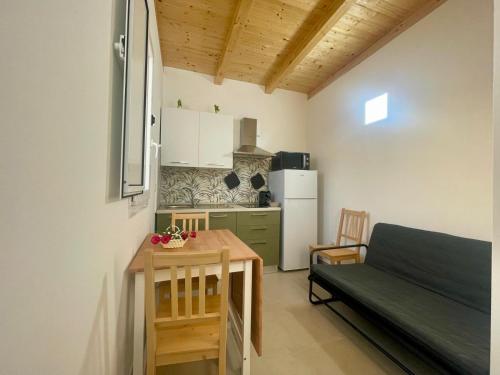 Una cocina con una mesa y un sofá en una habitación. en Anastasia Beach Cottage POMELIA, en Fontane Bianche