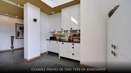 a kitchen with white cabinets and a counter top at Norweska Dolina Family&Pet-friendly Resort in Szklarska Poręba