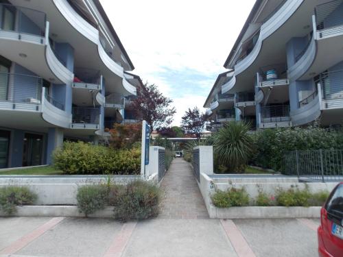 a walkway in a parking lot next to some apartment buildings at Costa Azzurra Apartment in Grado