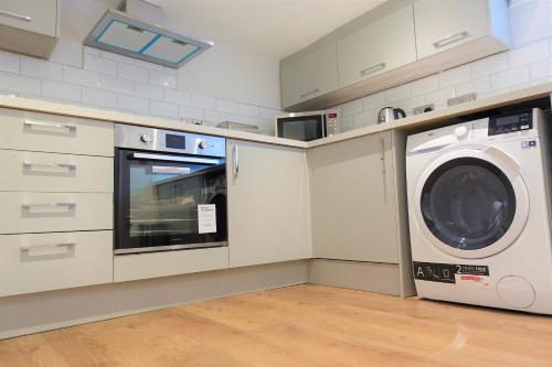 a kitchen with a washer and a washing machine at BrickSage Rooms, King's Lynn The Walks in Kings Lynn