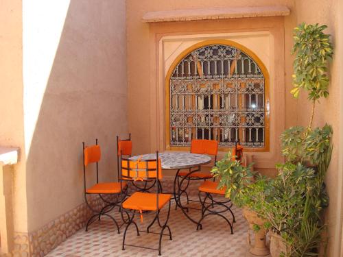 a patio with a table and chairs and a window at Kasbah Ait Kassi in Boumalne