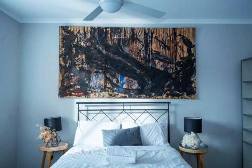 a bedroom with a bed with a painting on the wall at Contemporary 2BR apartment near Kingston - Hosted by Canstay in Kingston 