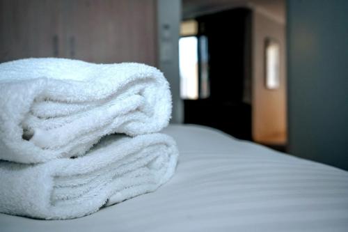 a pile of white towels sitting on top of a bed at Contemporary 2BR apartment near Kingston - Hosted by Canstay in Kingston 