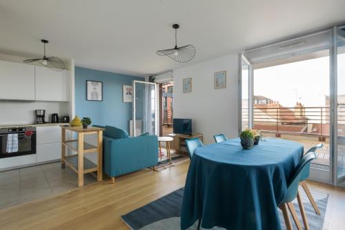 un salon avec une table et un chiffon bleu dans l'établissement Les Marronniers - A 15min du Stade de France, à Aulnay-sous-Bois