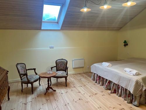 a room with a bed and two chairs and a table at Ledainė in Naujasodis