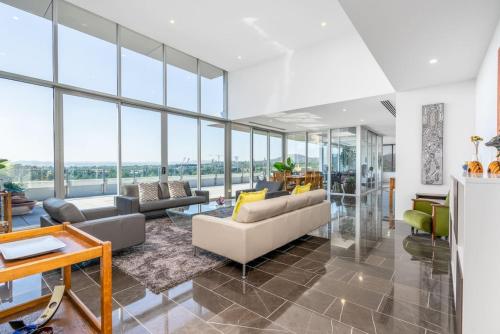 a living room filled with furniture and glass windows at Modern 3BR Home 5 mins away from Parliament House - Hosted by Canstay in Barton