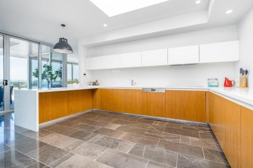 a kitchen with white counters and wooden cabinets at Modern 3BR Home 5 mins away from Parliament House - Hosted by Canstay in Barton