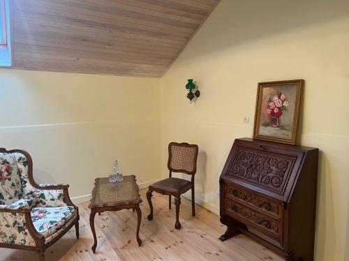 a living room with two chairs and a dresser at Ledainė in Naujasodis