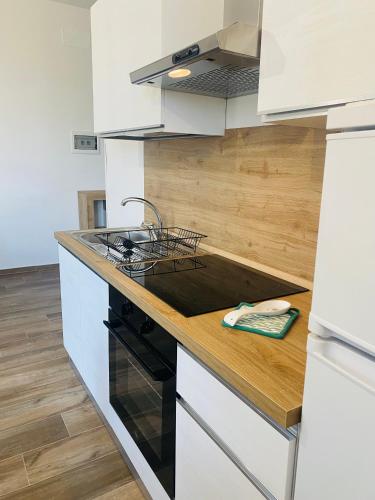 a kitchen with white cabinets and a black stove top oven at Relais Green Paradise in Apice