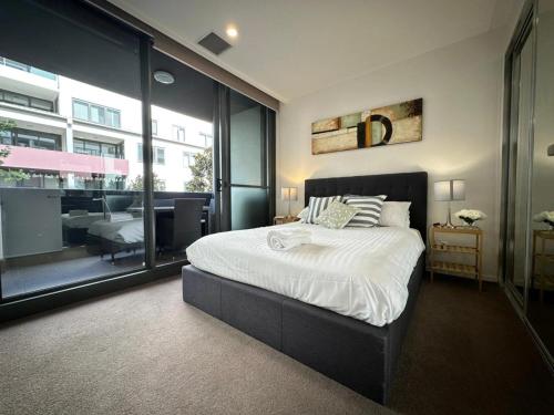 a bedroom with a large bed and a large window at Cosy getaway in the Heart of Braddon - Hosted by Canstay in Canberra