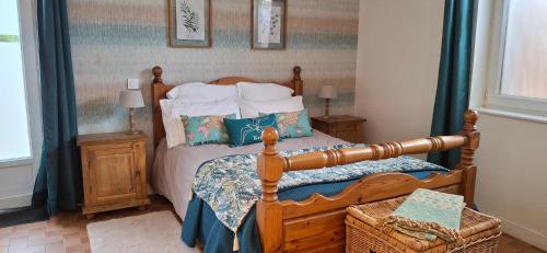 - une chambre avec un lit en bois et des oreillers dans l'établissement Le Black Dog Pub, à Saint-Aignan