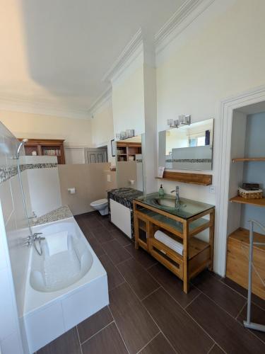 une grande salle de bain avec une baignoire et un lavabo dans l'établissement Château Sainte Colombe, à Saint-Geniès-des-Mourgues