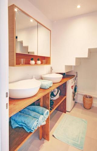 une salle de bain avec deux lavabos et un miroir dans l'établissement Maisonnette Key'sea havre de paix en bord de mer, à Frontignan