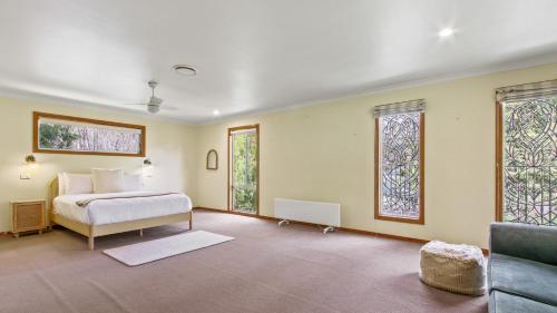 a bedroom with a bed and two windows at Casa Mia Metung in Metung