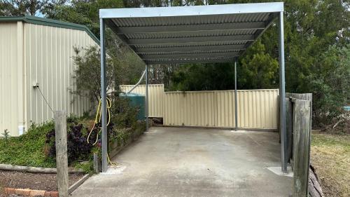 a garage with a metal canopy over a driveway at Casa Mia Metung in Metung