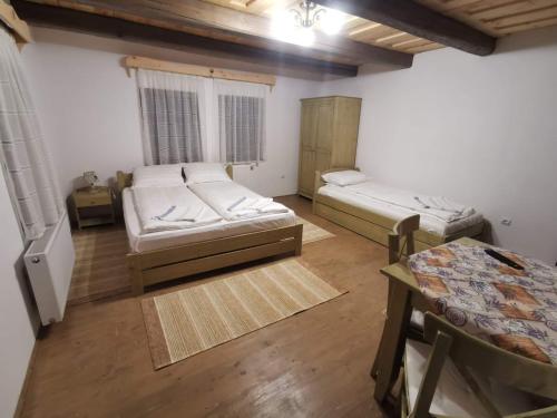 a room with two beds and a table at Pensiunea Gerendás Vendégház in Vlăhiţa