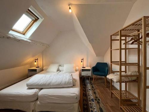 ein Schlafzimmer mit zwei Betten und einem Etagenbett in der Unterkunft Maison charmante à Bec-de-Mortagne avec jardin clôturé in Bec-de-Mortagne