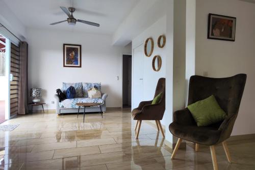 a living room with two chairs and a couch at Neanava Lodge Papeete in Papeete