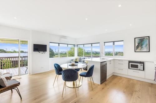 a kitchen and living room with a table and chairs at Sensational Rest in Auckland