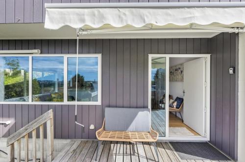 a porch with a wicker chair on a house at Sensational Rest in Auckland