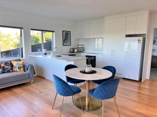 a kitchen and living room with a table and chairs at Sensational Rest in Auckland