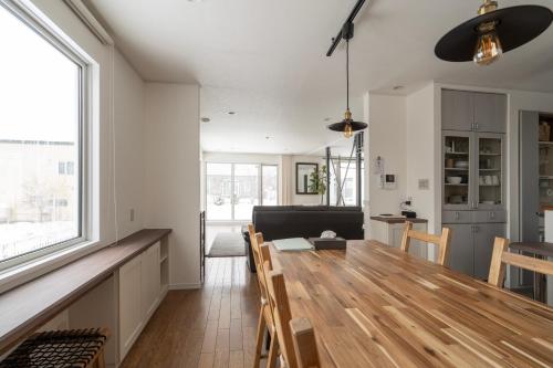 a kitchen and dining room with a wooden table and chairs at Perfect Winter Villa Retreat - 14 minutes to downtown in Sapporo