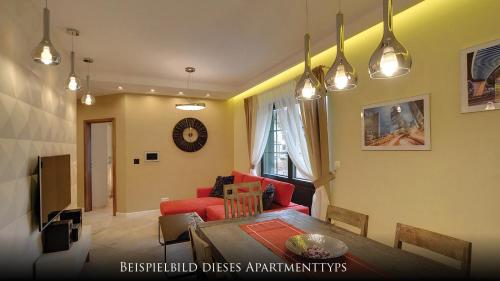 a living room with a red couch and a table at Norweska Dolina Family&Pet-friendly Resort in Szklarska Poręba