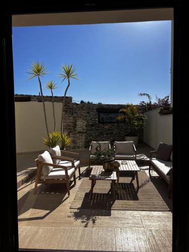 a patio with couches and a table and chairs at Elysium Luxury Stays in Melegis