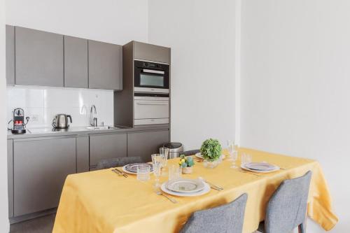 une cuisine avec une table et un chiffon de table jaune dans l'établissement Charmant Appartement 4P- Face ARC de Triomphe, à Paris