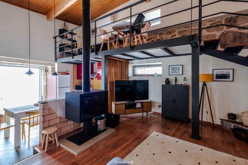 a living room with a fireplace and a loft at Casa Ti Maria in Sorval