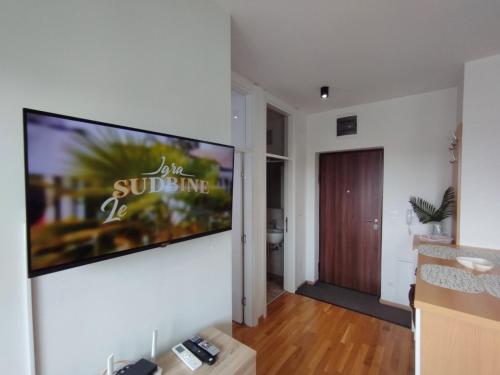 a living room with a large flat screen tv on a wall at Astra apartman BL in Banja Luka